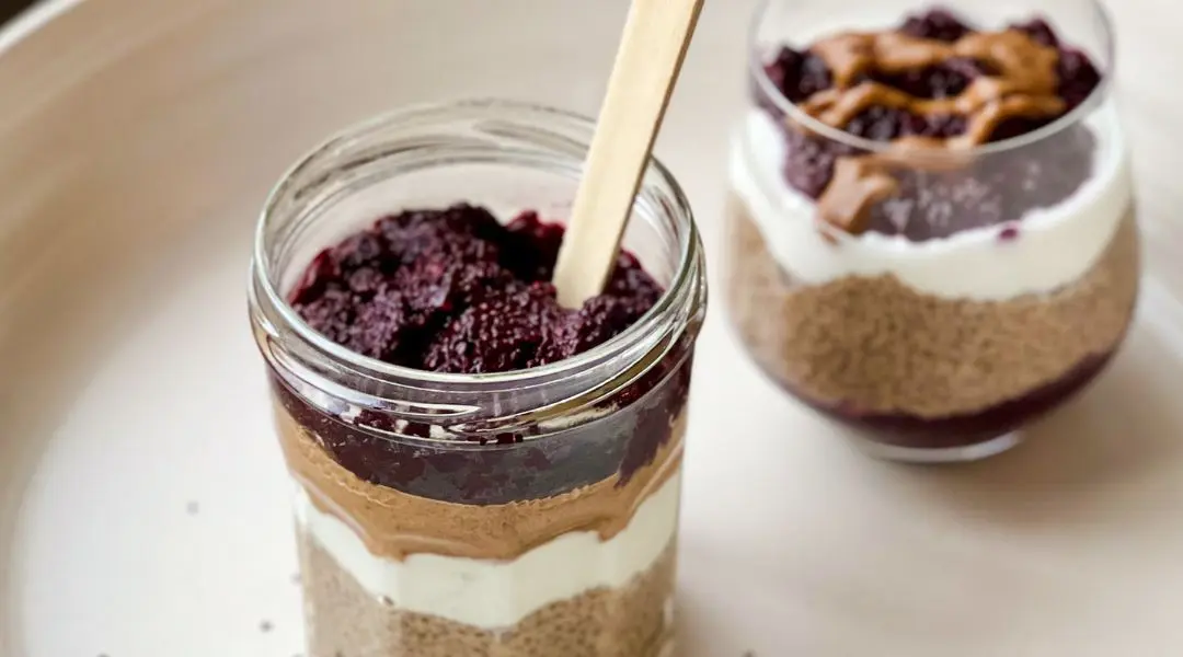 Parfait au chia avec yogourt, beurre de noix et petits fruits dans un pot