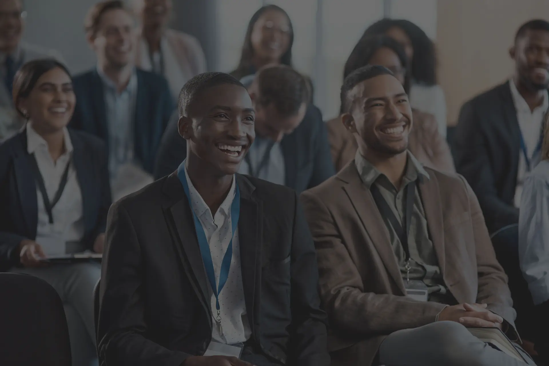 Participants souriants lors d'une conférence | Smiling attendees at a conference