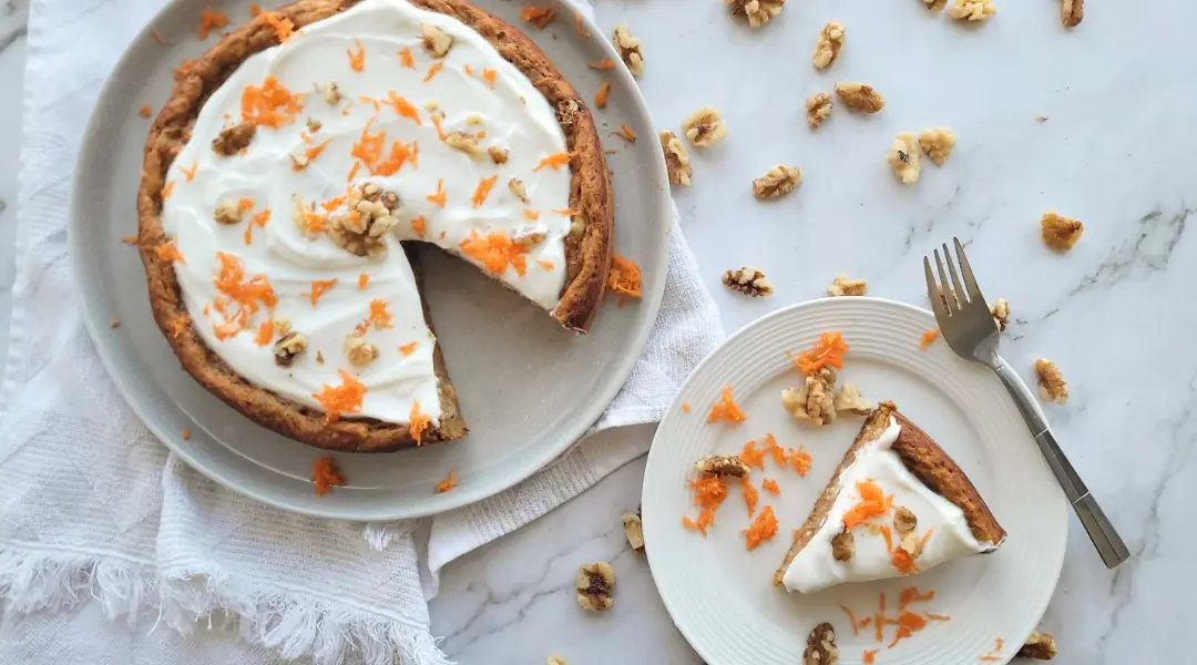 Gâteau aux carottes glacé au fromage à la crème, décoré de noix et carottes râpées