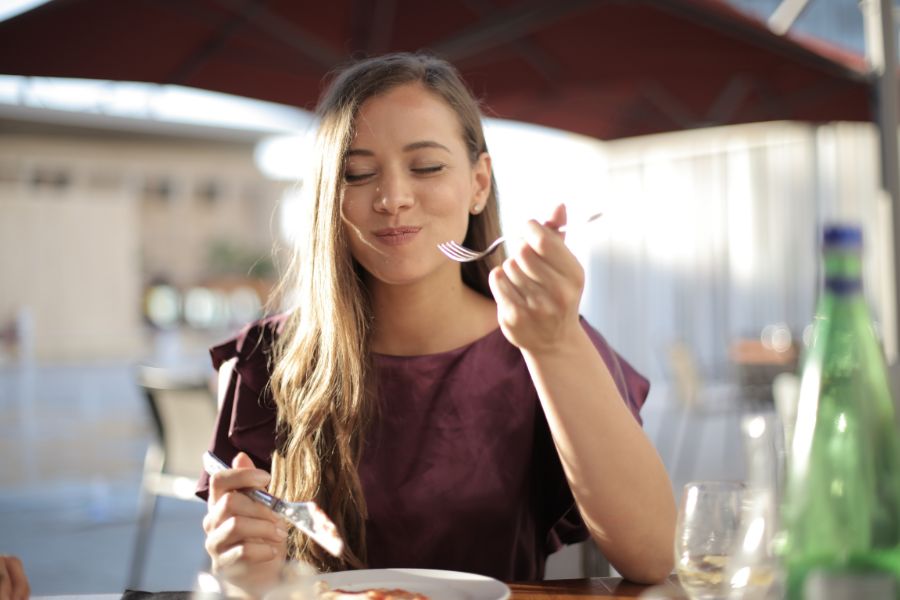 Woman enjoying her meal at an outdoor dining table