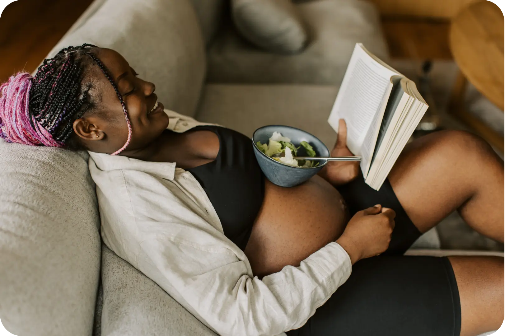 Femme enceinte lisant un livre avec une salade