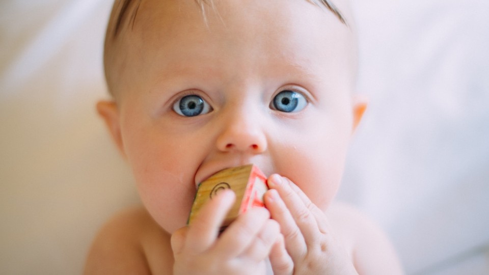 bébé aux yeux bleus qui fait ses dents