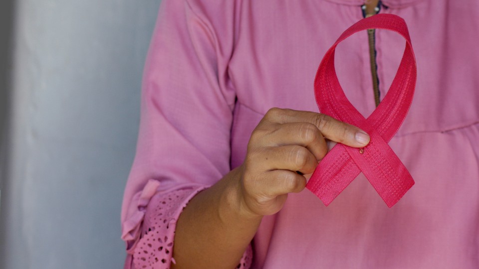 femme qui tient un ruban rose représentant le cancer du sein