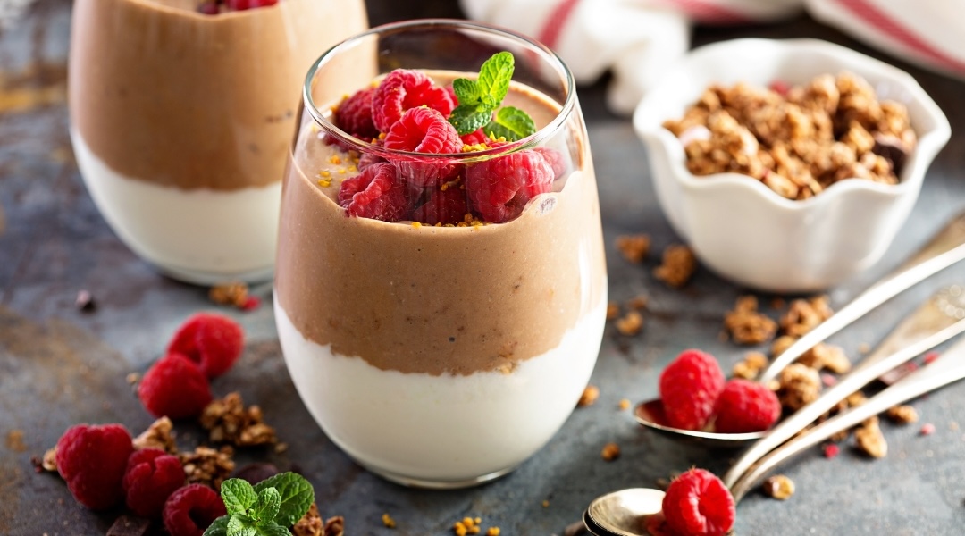 5 façons de réduire sa consommation de glucides chocolate mousse in a glass with raspberries and granola