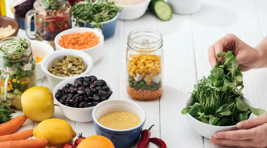 A person is holding a bowl of vegetables and other healthy ingredients for cholesterol management