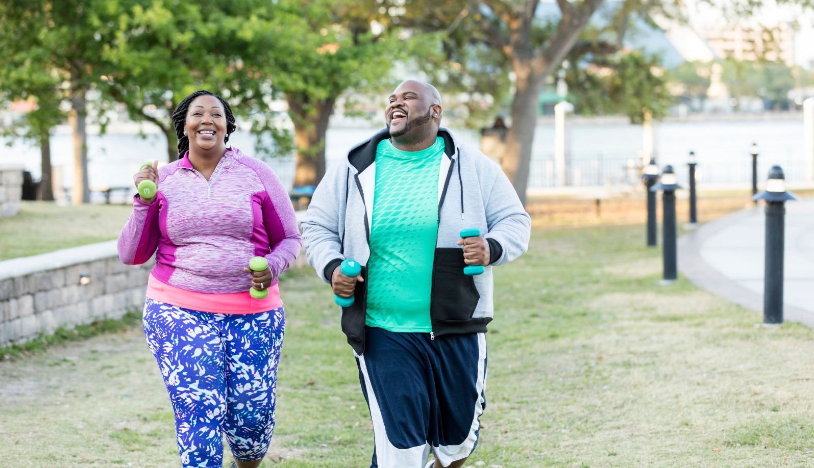 A smiling plus size couple jogs outdoors - Un couple en surpoids souriant fait du jogging en extérieur