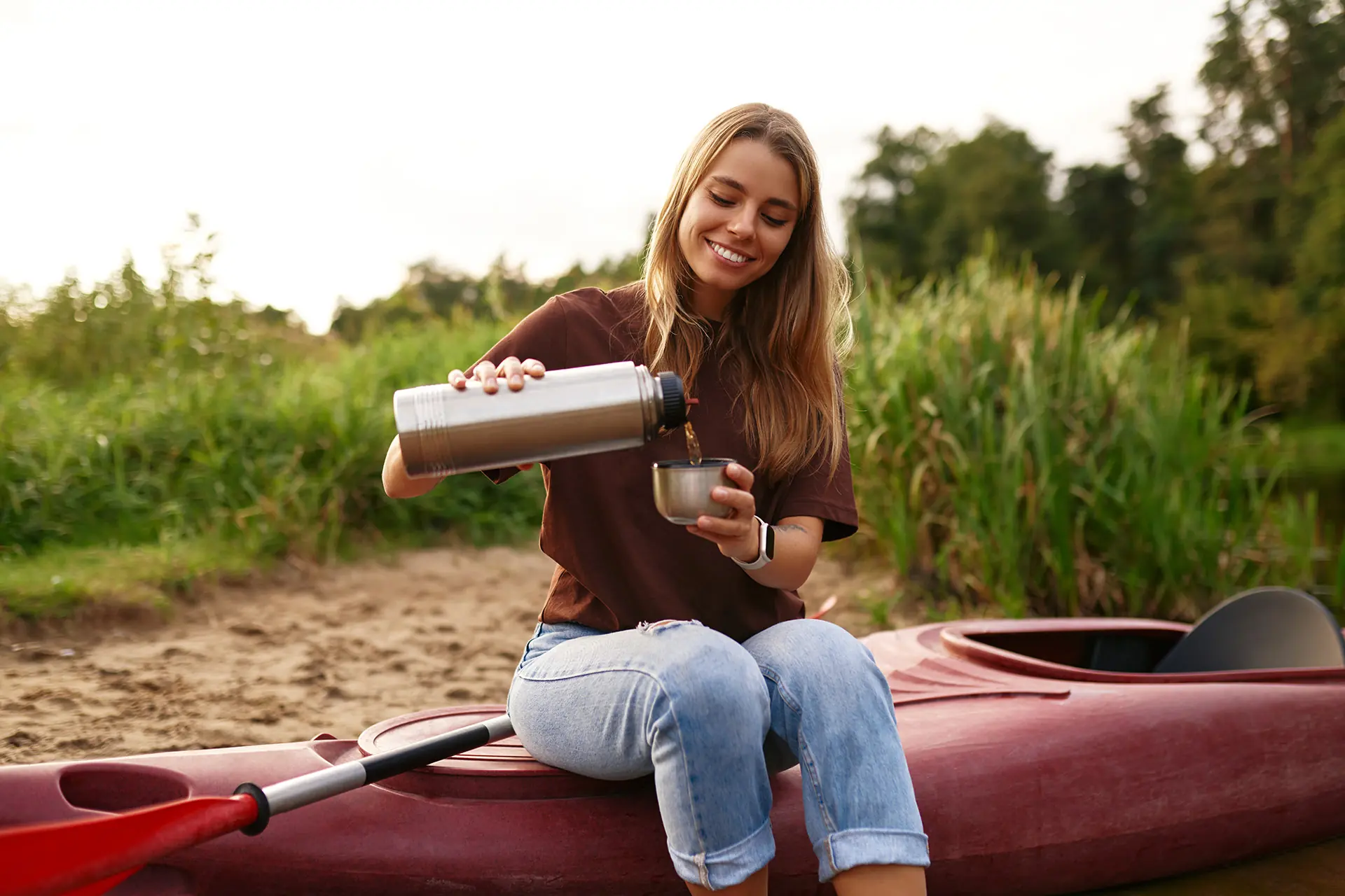 femme qui se verse une boisson assise sur un kayak à Cap-Rouge ÉquipeNutrition TeamNutrition