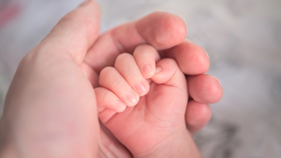 Main d'un bébé dans la main de sa mère