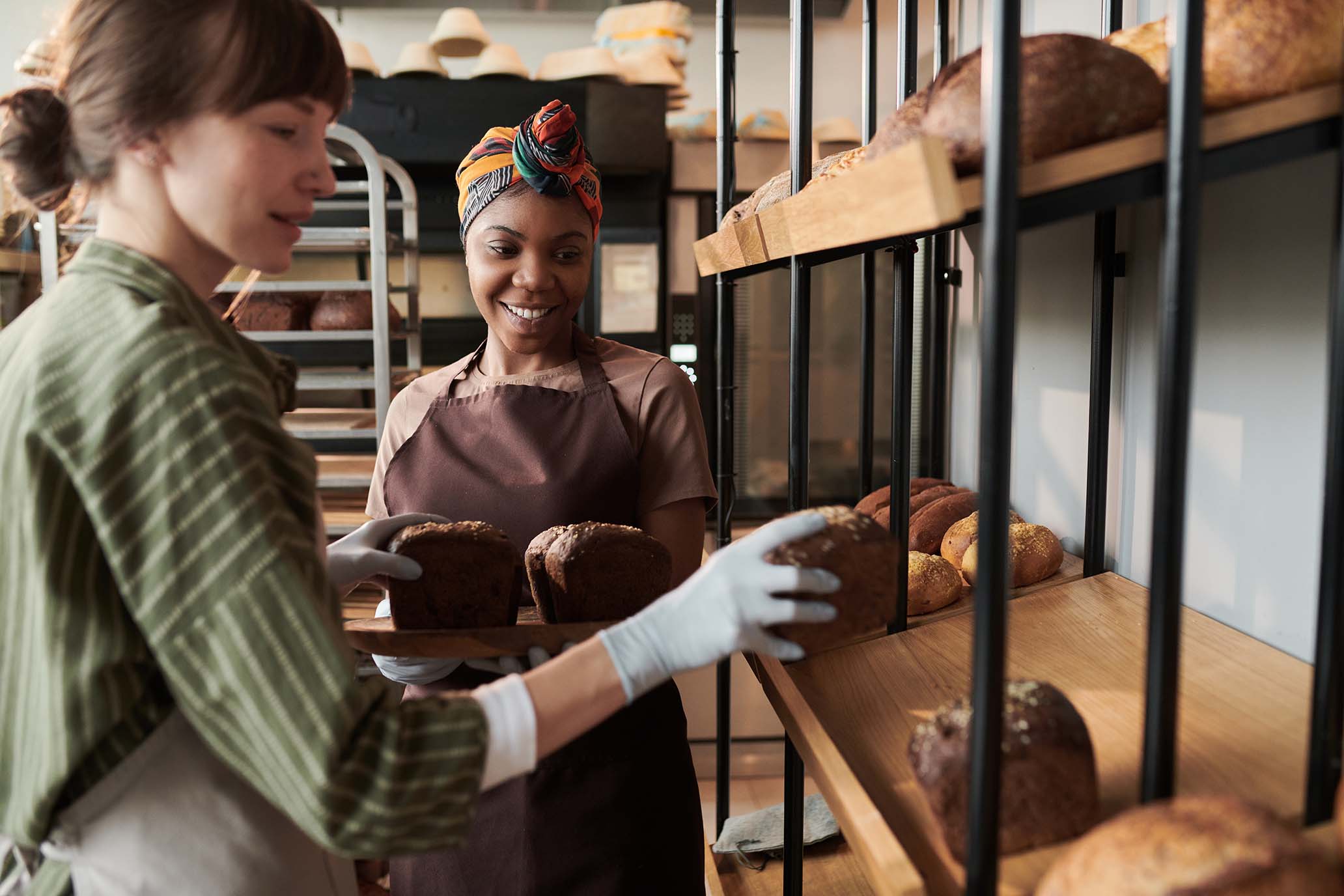 Two bakers arranging fresh loaves of bread - Deux boulangères disposant des pains frais