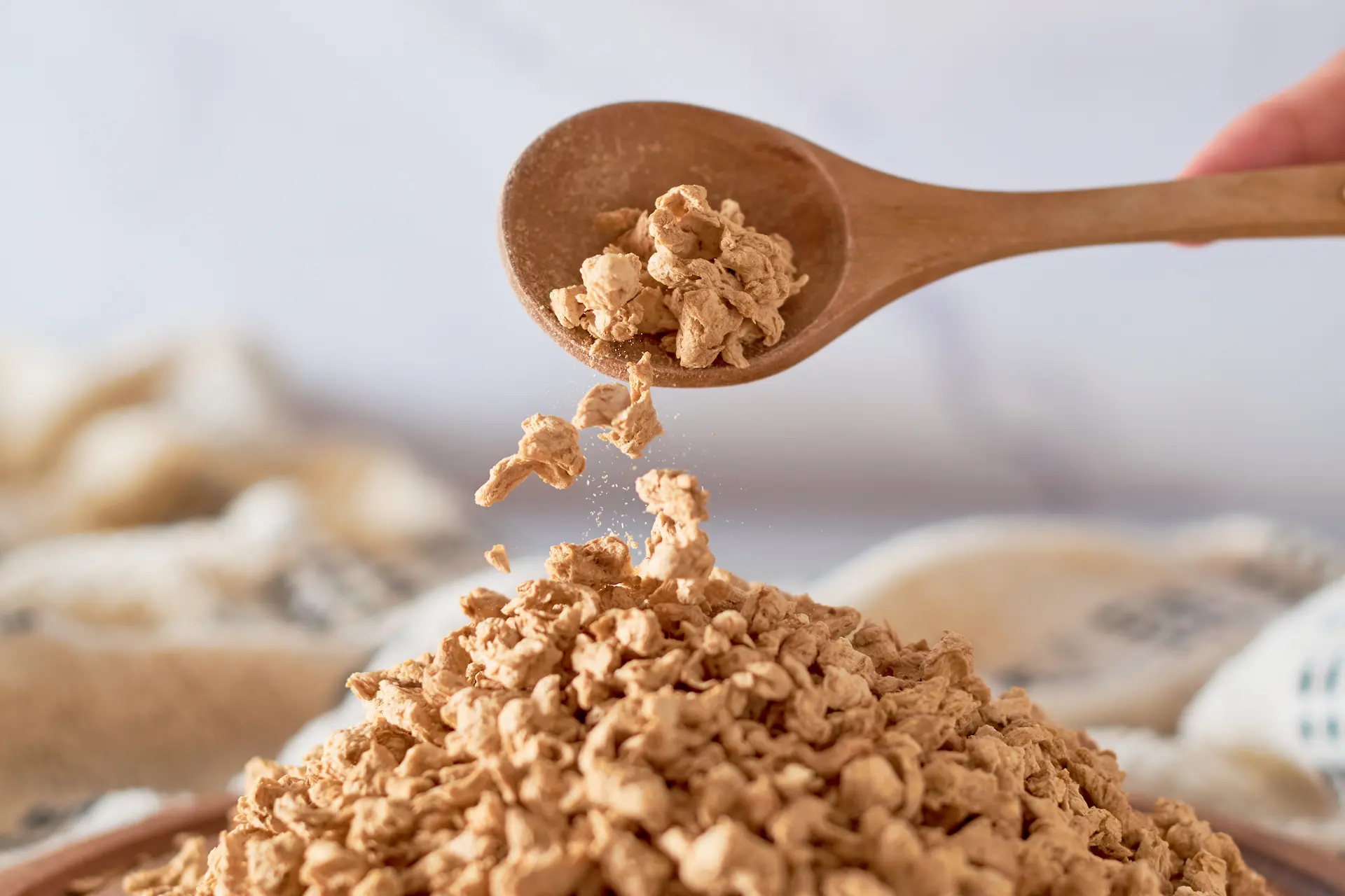 Cuillère en bois versant des protéines végétales texturées séchées - Wooden spoon pouring dried textured vegetable protein