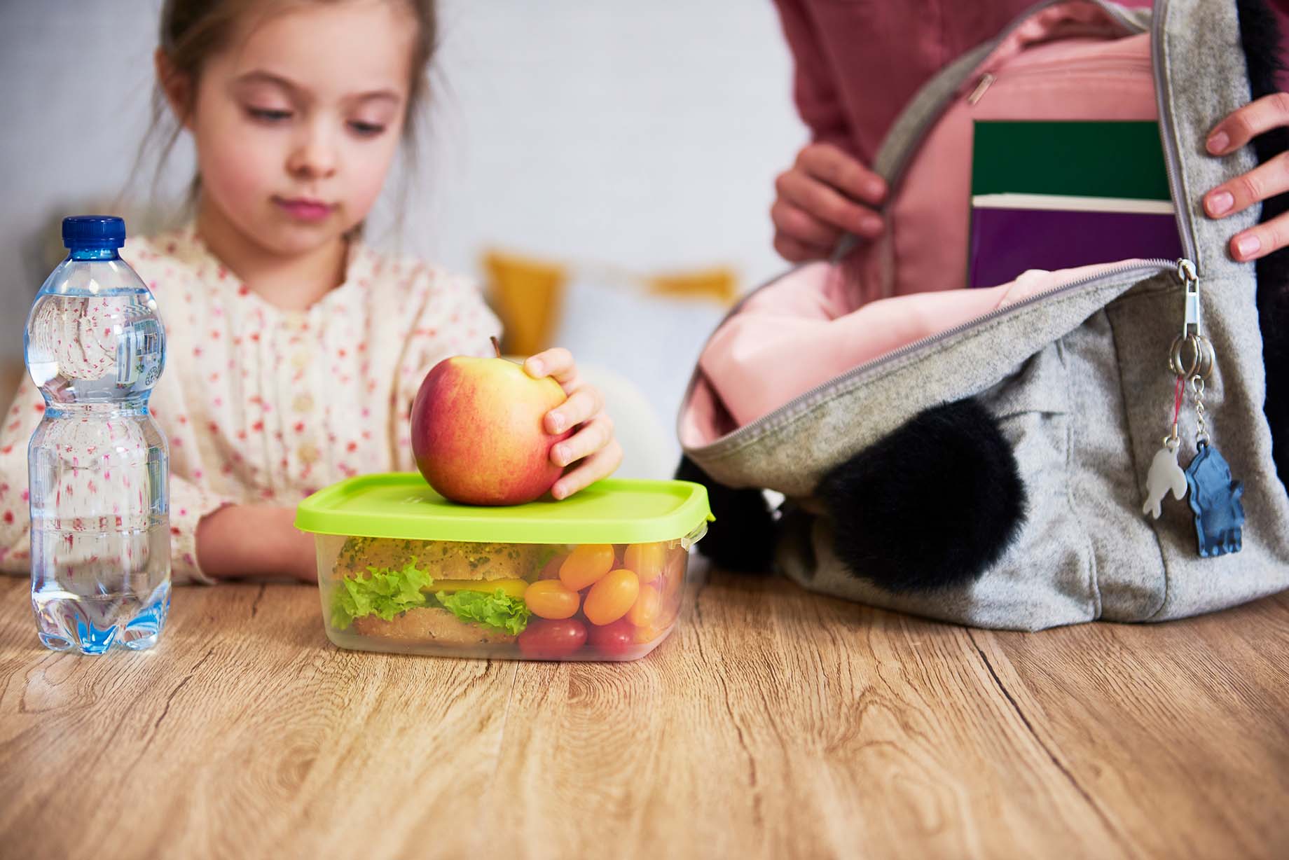 A young girl with an apple, packing a healthy lunch with a sandwich and tomatoes - Une jeune fille avec une pomme, préparant un lunch sain avec un sandwich et des tomates