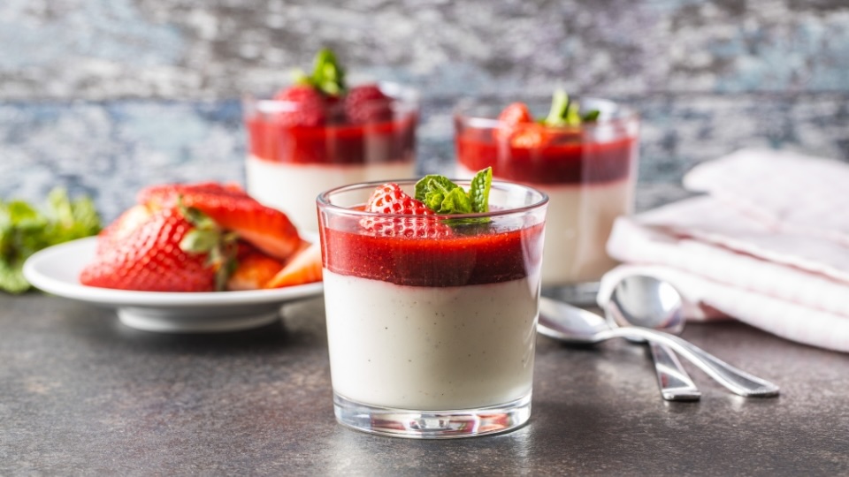 Delicate dessert topped with fresh strawberry sauce and berries, ready to be enjoyed, highlighting a healthy and elegant treat.