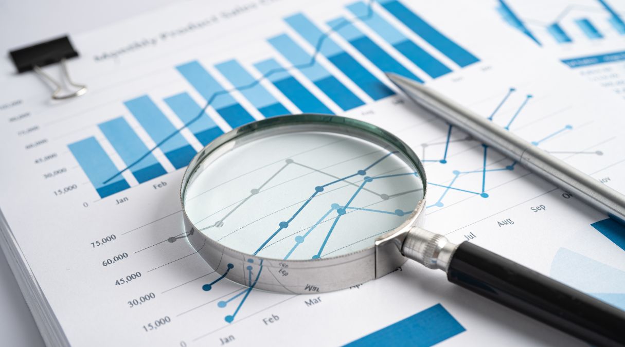 Loupe sur un graphique à barres bleu et blanc, montrant l'analyse des ventes mensuelles