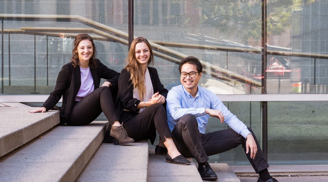 three business dietitian sitting on steps in front of a building