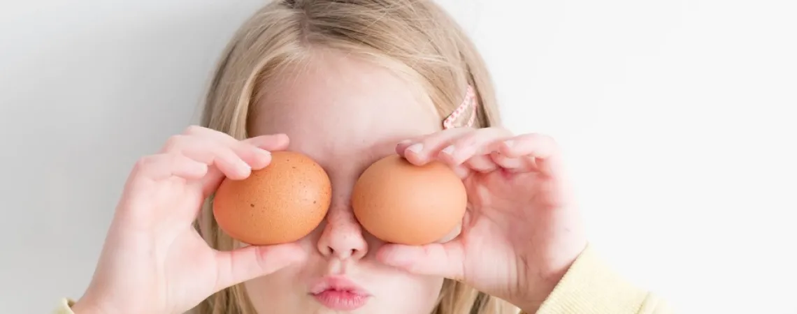 enfant se cachant les yeux avec des oeufs