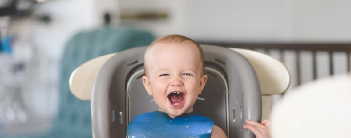 bébé souriant sur la chaise haute