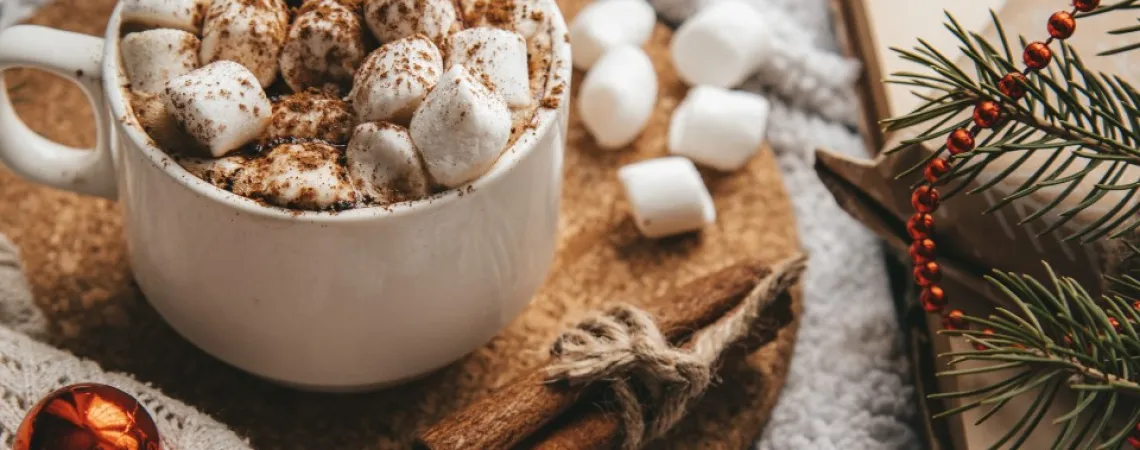 chocolat chaud avec guimauves sur une tables décorée pour Noël