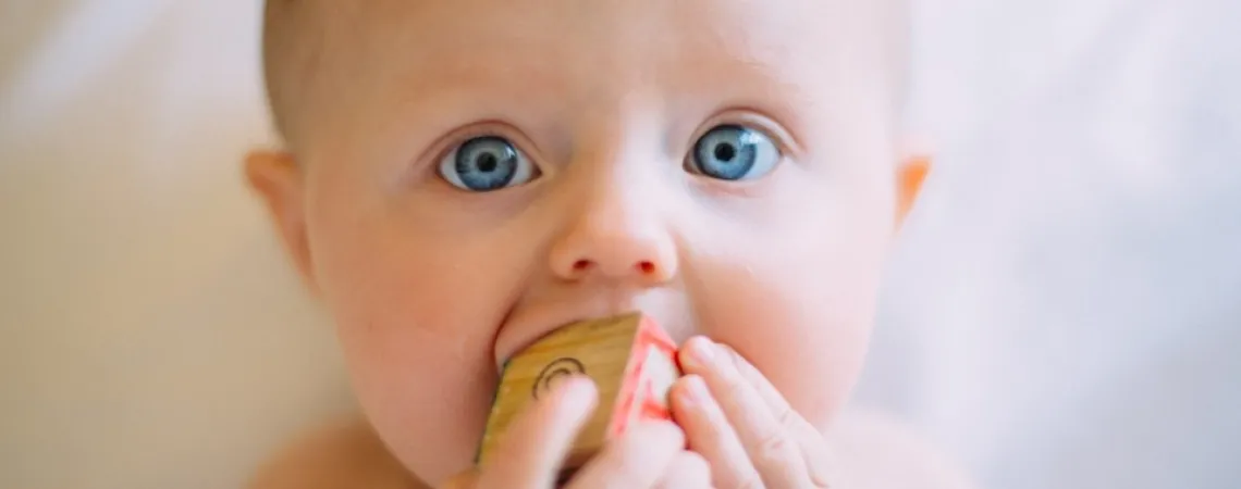 bébé aux yeux bleus qui fait ses dents