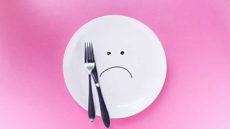 Assiette triste vide avec une fourchette et un couteau