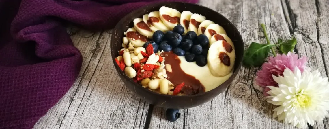 Bol de yogourt et/ou smoothie sur un fond de bois avec une couverture mauve