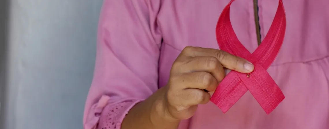femme qui tient un ruban rose représentant le cancer du sein