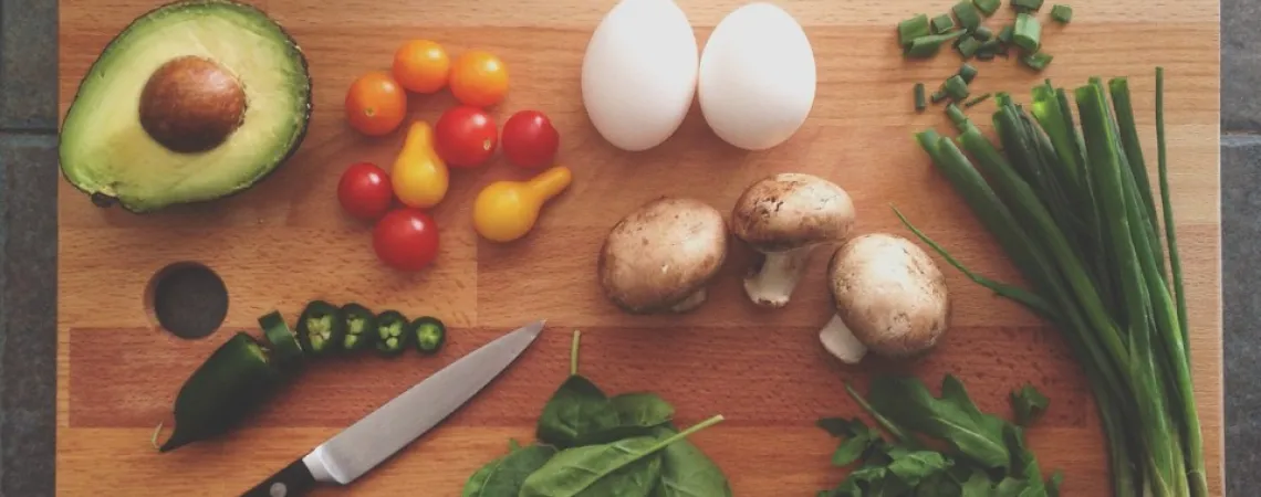 légumes et protéines sur une planche à découper en bois