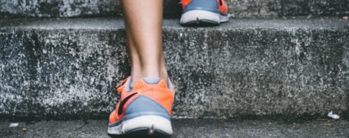 individu montant les escaliers avec ses souliers de sport