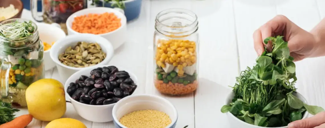 A person is holding a bowl of vegetables and other healthy ingredients for cholesterol management