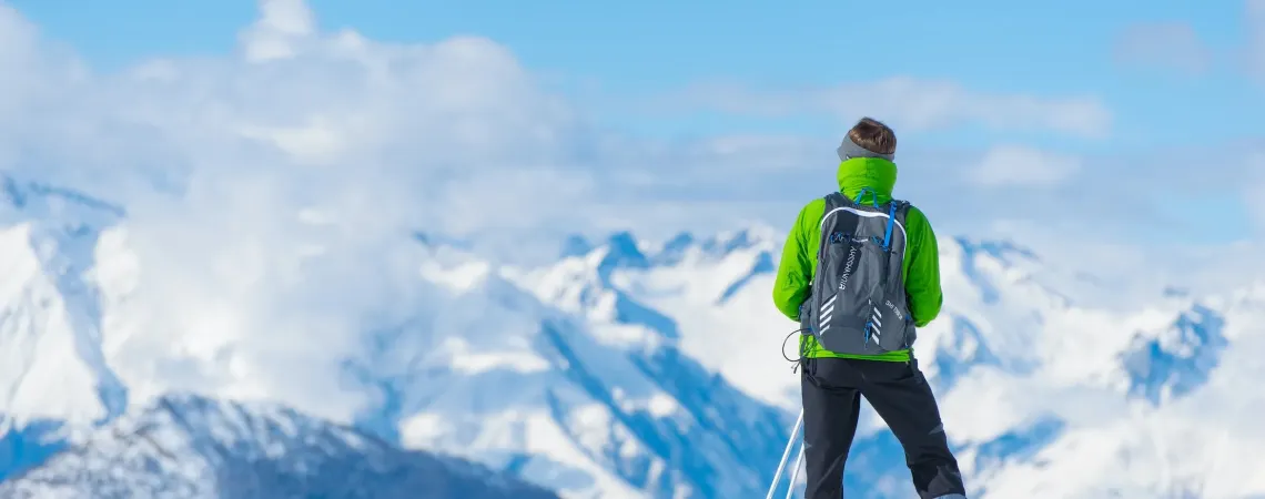 Homme sur une montagne enneigée regardant au loin
