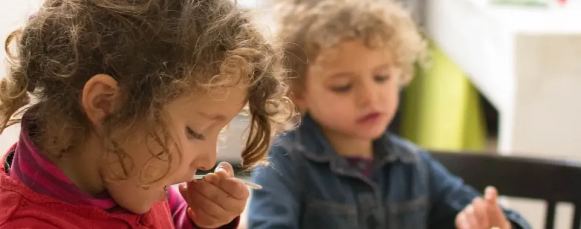 deux fillettes qui goûtent à des fruits