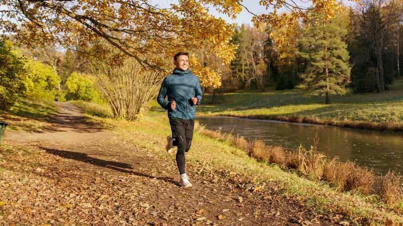 Homme courant sur un sentier d'automne - Man jogging on a leafy autumn trail