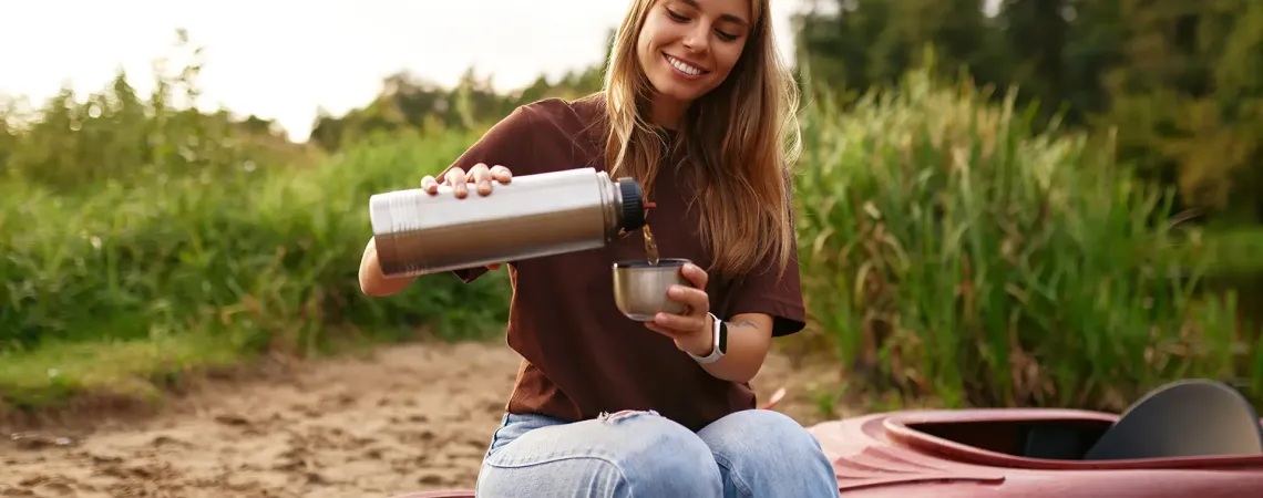 femme qui se verse une boisson assise sur un kayak à Cap-Rouge ÉquipeNutrition TeamNutrition