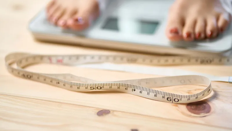 Pieds sur une balance avec ruban à mesurer - Feet on scale with measuring tape
