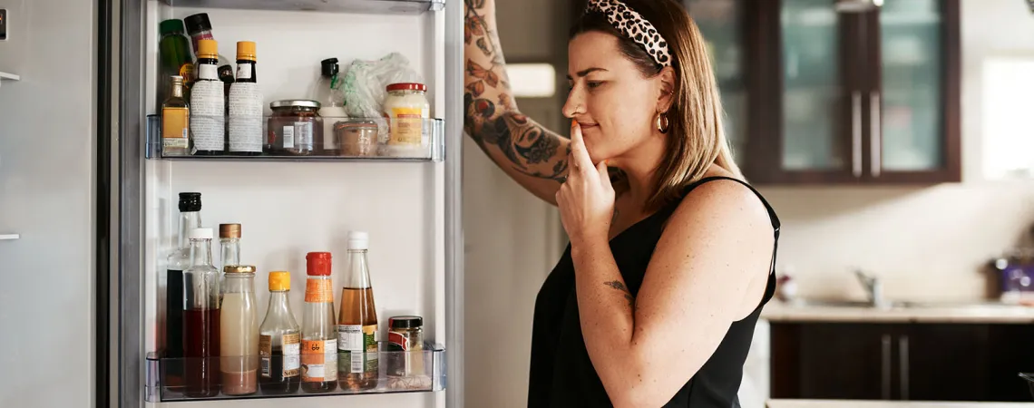 Femme regardant dans le réfrigérateur - Woman looking at fridge content