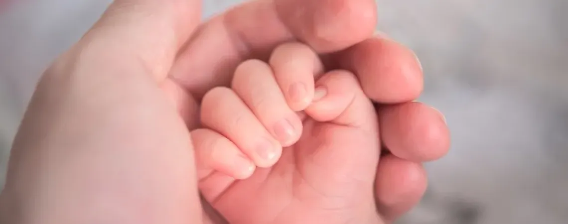 Main d'un bébé dans la main de sa mère