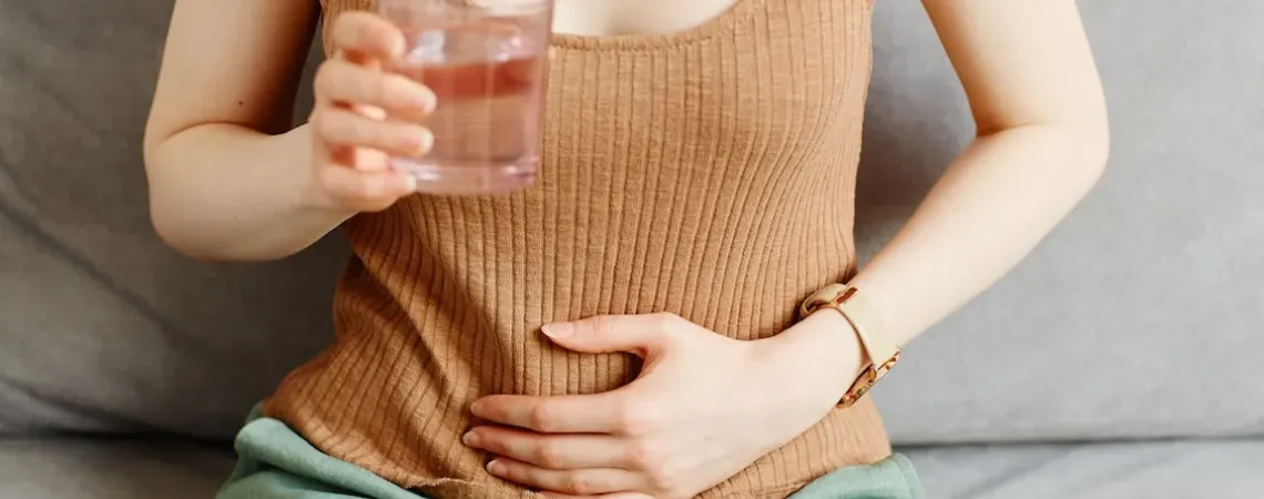 femme mal au ventre verre d'eau Stratégies nutritionnelles pour les MII en rémission ÉquipeNutrition TeamNutrition
