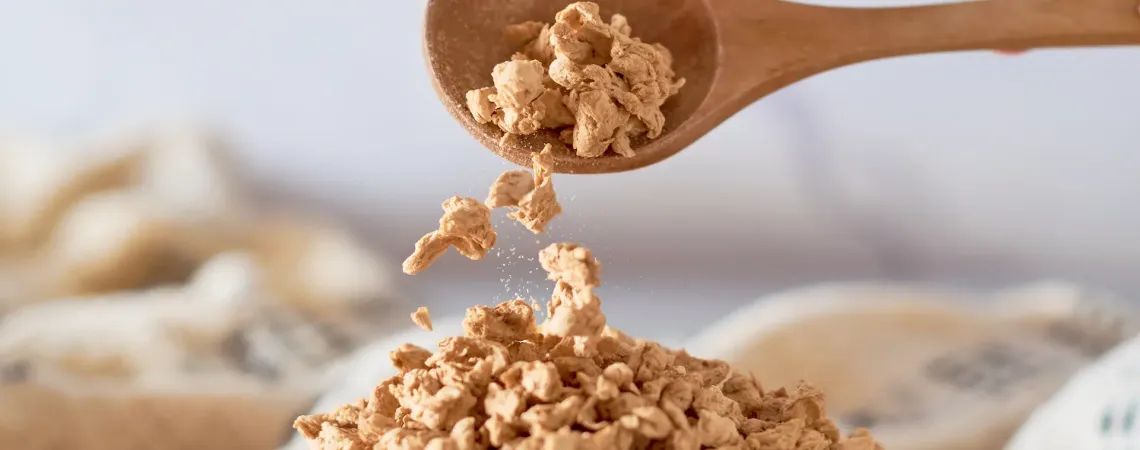 Cuillère en bois versant des protéines végétales texturées séchées - Wooden spoon pouring dried textured vegetable protein