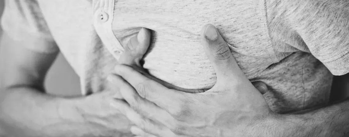 homme avec les mains sur le torse à cause de reflux gastriques