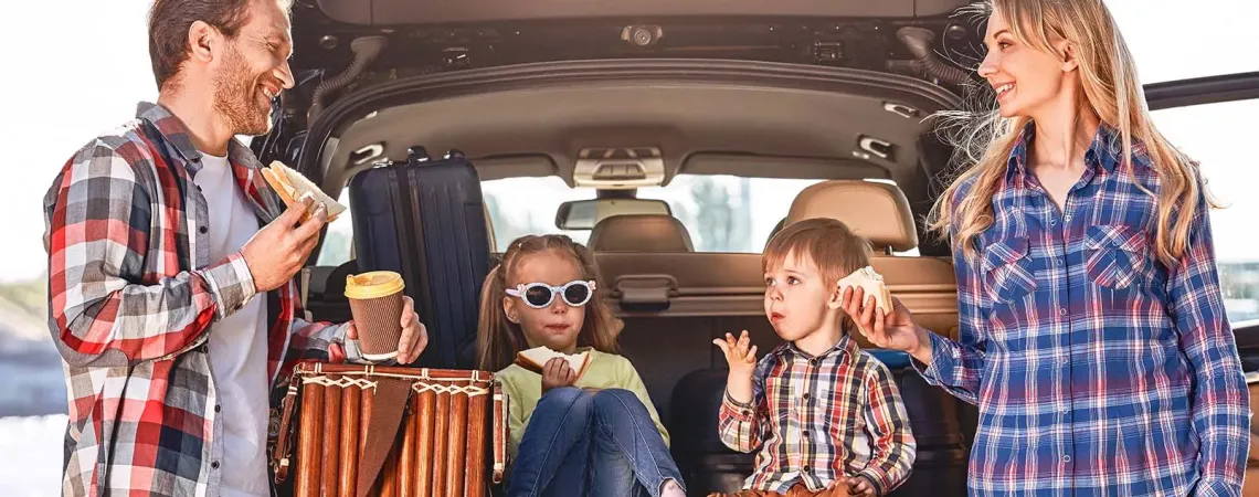 Famille prenant une collation près de la voiture - Family having a snack by the car