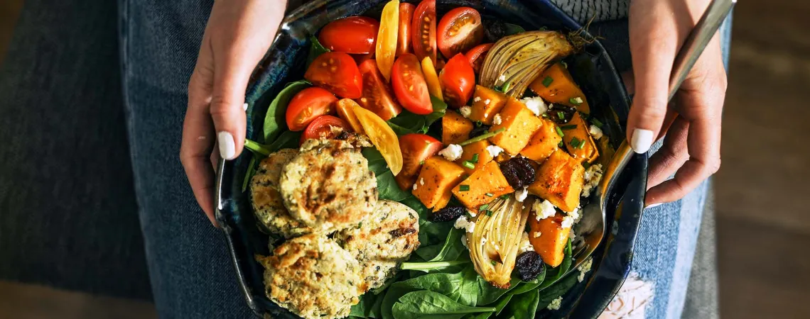 Assiette végane tenue par une femme - Vegan plate held by a woman