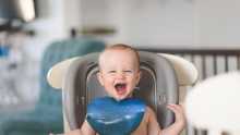 bébé souriant sur la chaise haute