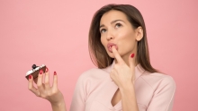 Femme qui mange un gateau devant un écran rose