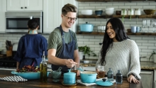 trois personnes qui cuisinent ensemble en souriant
