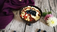 Bol de yogourt et/ou smoothie sur un fond de bois avec une couverture mauve