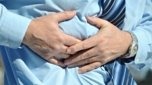 homme avec une chemise bleu qui a des douleurs abdominales