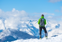 Homme sur une montagne enneigée regardant au loin