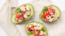 Trois moitiés d'avocat farcies avec feta, tomates, menthe et grenade