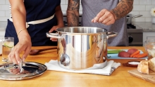 deux personnes cuisinant autour d'un gros chaudron
