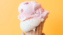 cornet de crème glacé rose et blanche sur fond orange