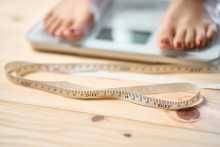 Pieds sur une balance avec ruban à mesurer - Feet on scale with measuring tape